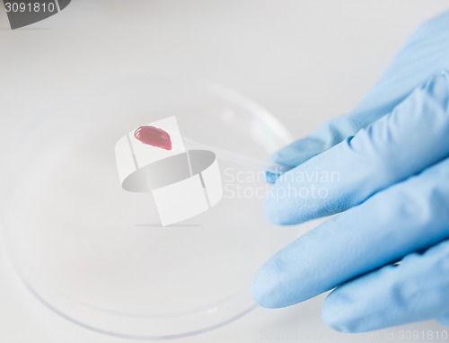 Image of close up of scientist with blood sample in lab