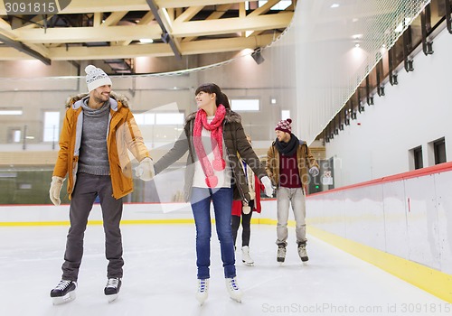 Image of happy friends on skating rink