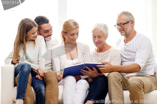 Image of happy family with book or photo album at home