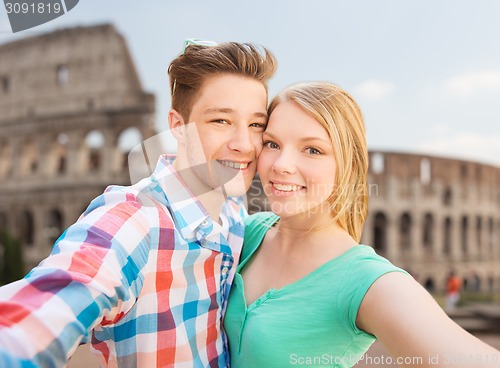 Image of smiling couple taking selfie over coliseum