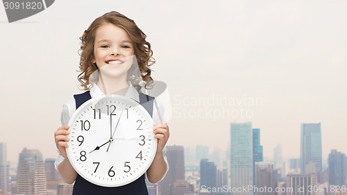 Image of smiling girl holding big clock