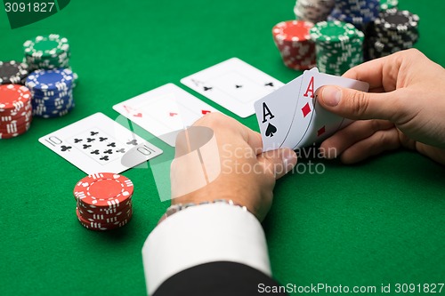 Image of poker player with cards and chips at casino