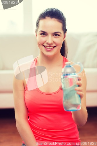 Image of smiling girl with bottle of water after exercising