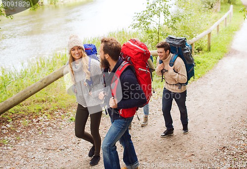 Image of group of smiling friends with backpacks hiking