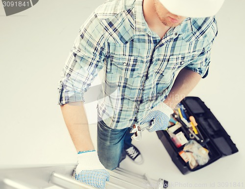 Image of man with ladder, toolkit and spanner