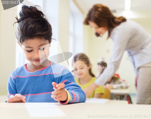 Image of happy little school girl over classroom background