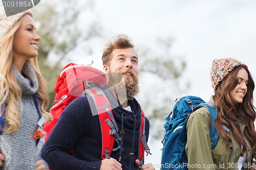 Image of group of smiling friends with backpacks hiking