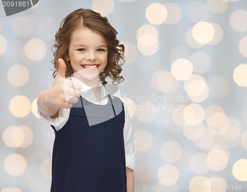 Image of happy little school girl showing thumbs up