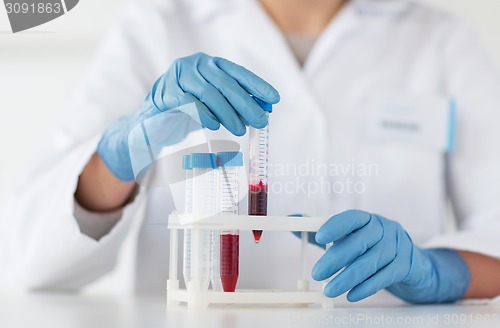 Image of close up of scientist with tube making test in lab