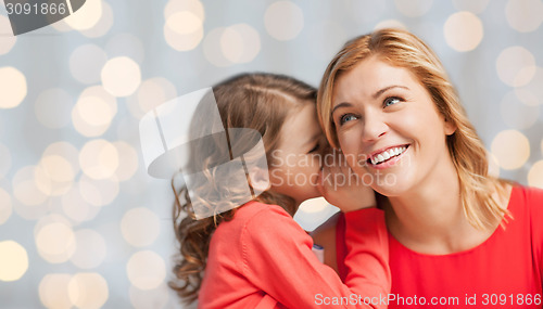 Image of happy daughter whispering gossip to her mother