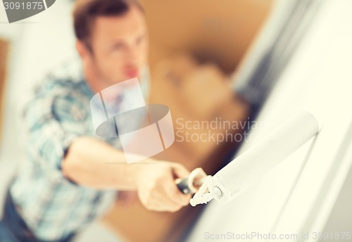 Image of man colouring the wall with roller