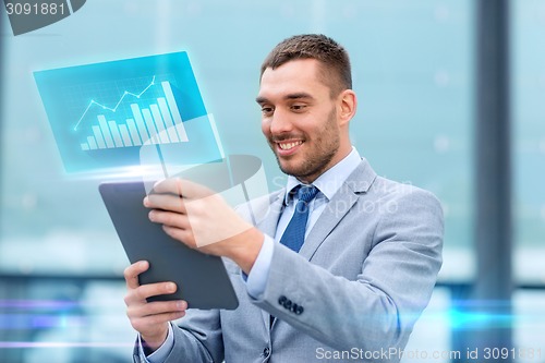 Image of smiling businessman with tablet pc outdoors