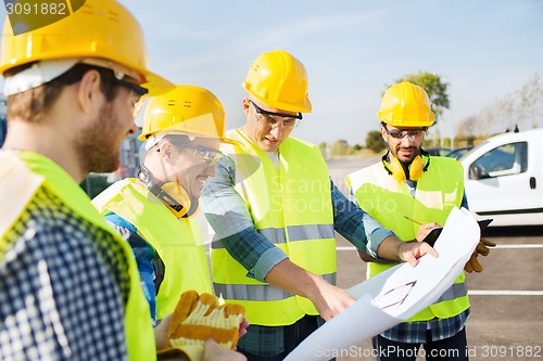 Image of group of builders with tablet pc and blueprint