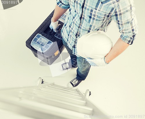 Image of man with ladder, helmet and toolkit