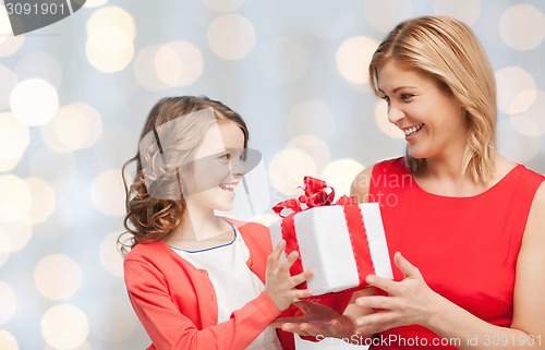 Image of happy mother and daughter with gift box