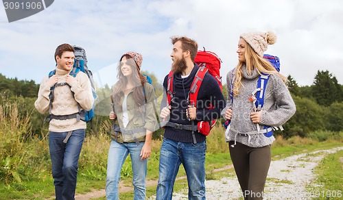 Image of group of smiling friends with backpacks hiking