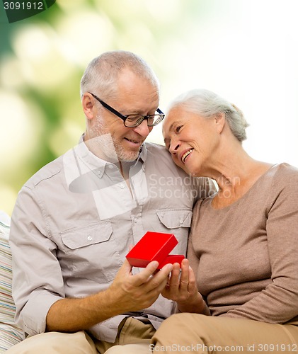 Image of happy senior couple with red gift box
