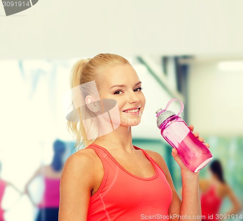 Image of smiling sporty woman with water bottle