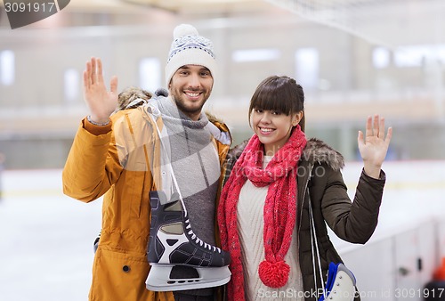 Image of happy couple with ice-skates on skating rink