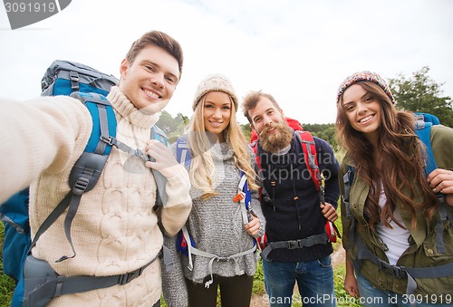 Image of group of smiling friends with backpacks hiking