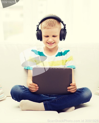 Image of little boy with tablet pc and headphones at home