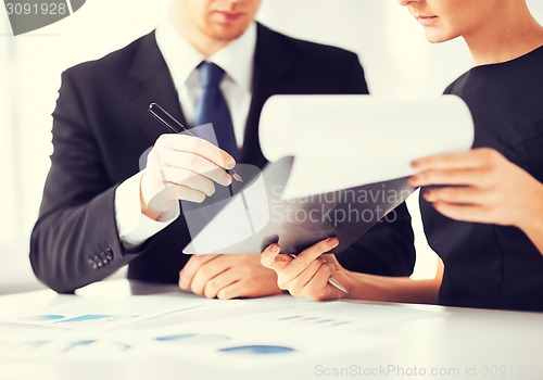 Image of businessman and businesswoman signing paper