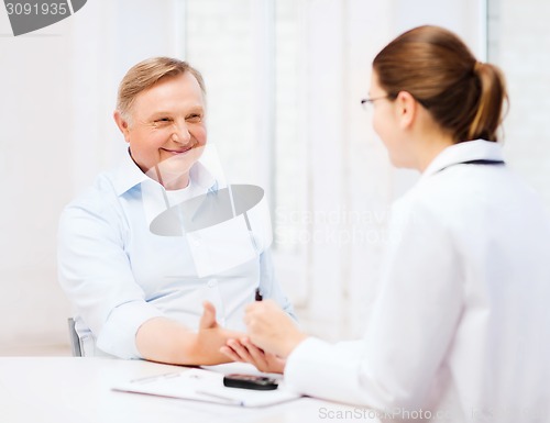 Image of female doctor or nurse measuring blood sugar value