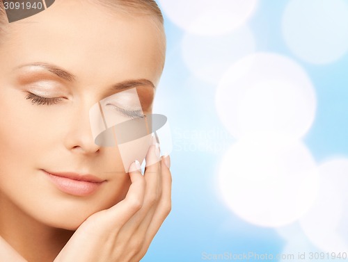 Image of beautiful young woman touching her face