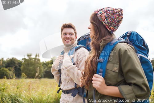 Image of smiling couple with backpacks hiking