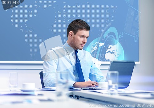 Image of businessman with laptop working in office