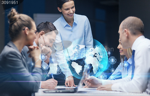 Image of smiling female boss talking to business team