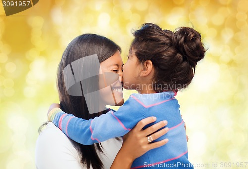 Image of happy little girl hugging and kissing her mother