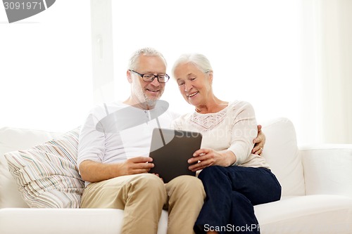 Image of happy senior couple with tablet pc at home