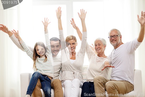 Image of happy family sitting on sofa at home