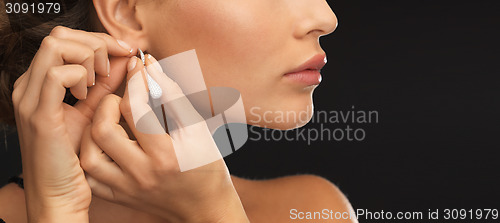 Image of woman wearing shiny diamond earrings