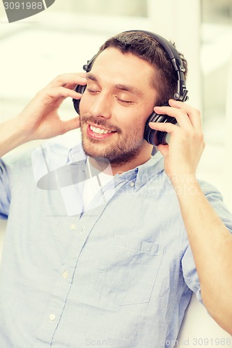 Image of smiling young man in headphones at home