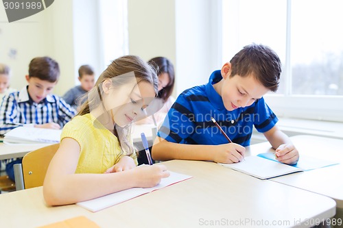 Image of group of school kids writing test in classroom