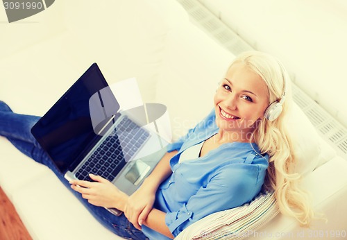 Image of woman with laptop computer and headphones at home