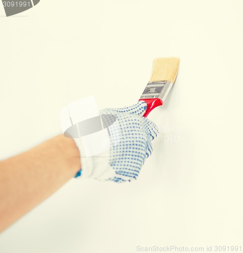 Image of hand coloring wall with paintbrush