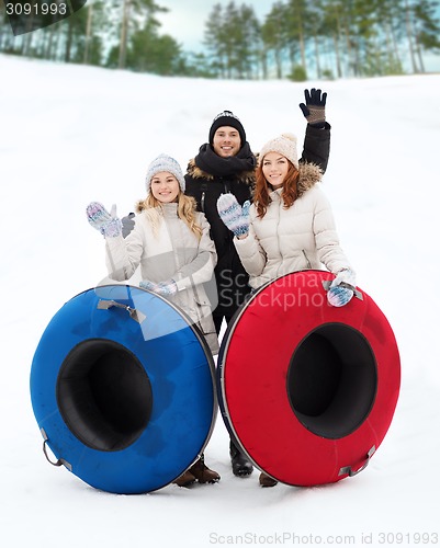 Image of group of smiling friends with snow tubes