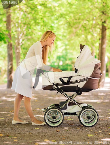 Image of happy mother with stroller in park