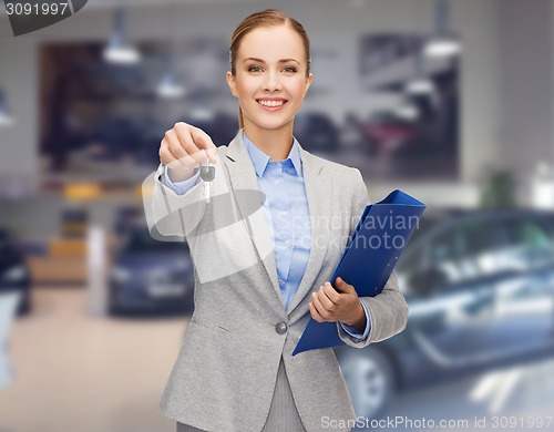Image of businesswoman or saleswoman giving car key