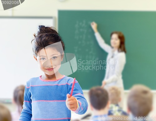 Image of happy little school girl over classroom background