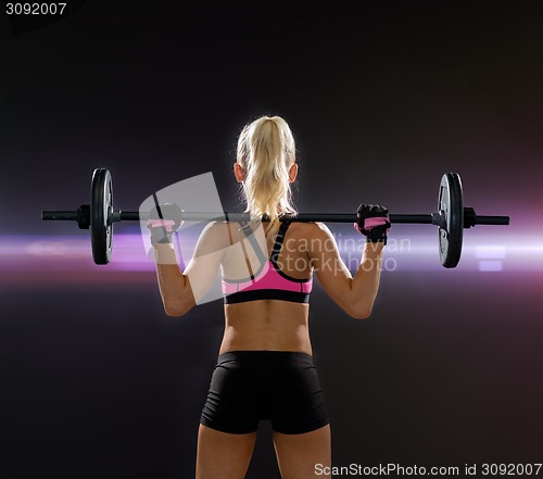 Image of sporty woman exercising with barbell from back