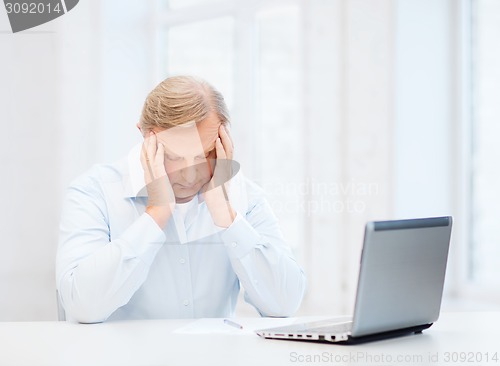 Image of stressed old man filling a form at home