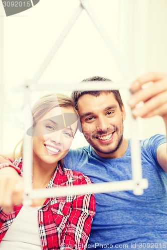 Image of smiling couple with house from measuring tape