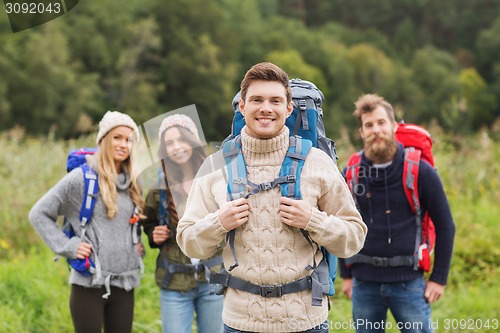 Image of group of smiling friends with backpacks hiking