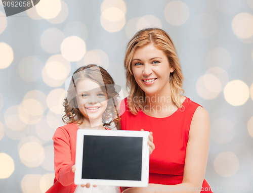 Image of mother and daughter with tablet pc over green