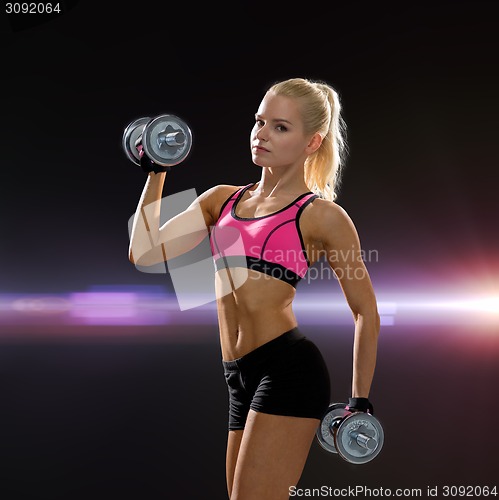 Image of sporty woman with heavy steel dumbbells