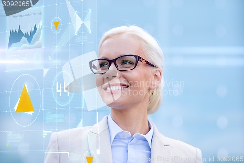 Image of young smiling businesswoman in eyeglasses outdoors